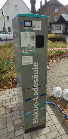 Seitenansicht einer grauen Ladesäule mit diversen Hinweisaufklebern und der Aufschrift „Elektro-Ladesäule