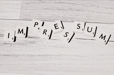 Buchstaben IMPRESSUM auf weißem Holzfussboden