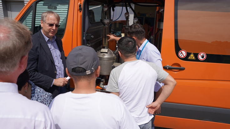 Mehre Personen stehn vor einem orangen Tankstellenbus