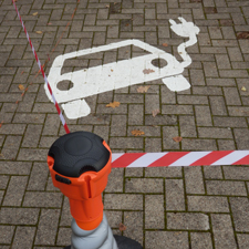 Ein auf Pflastersteinen gemaltes weißes Auto mit Stecker