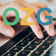 Eine Hand auf der Tastatur davor die Buchstaben OZG in Grüne, Gelb und Blau