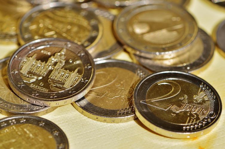 Mehrere 2 Euro Münzen liegen übereinander auf einem Tisch