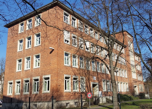 Seitenansicht des viergeschossigen Gebäudes der Betriebsstelle des Mess- und Eichwesen Niedersachsen in Hannover aus rotem Backstein vor blauem Himmel mit Flachdach